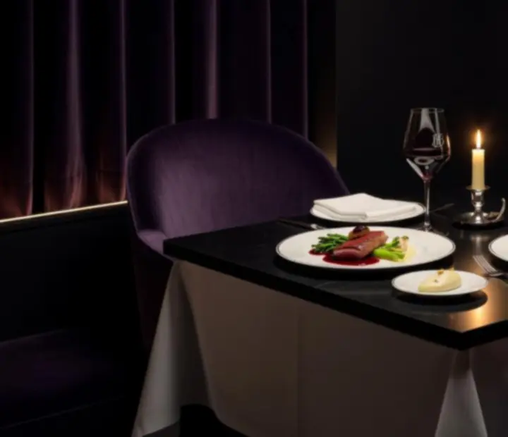 Table gastronomique nocturne avec dressage raffiné dans un bistro français.